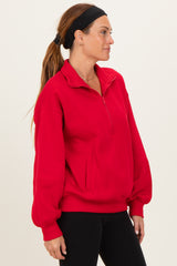 woman wearing a bright red quarter-zip pullover sweatshirt with a relaxed fit and side pockets