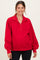 woman wearing a red maternity pullover sweatshirt with a half zip and relaxed fit, showing her baby bump