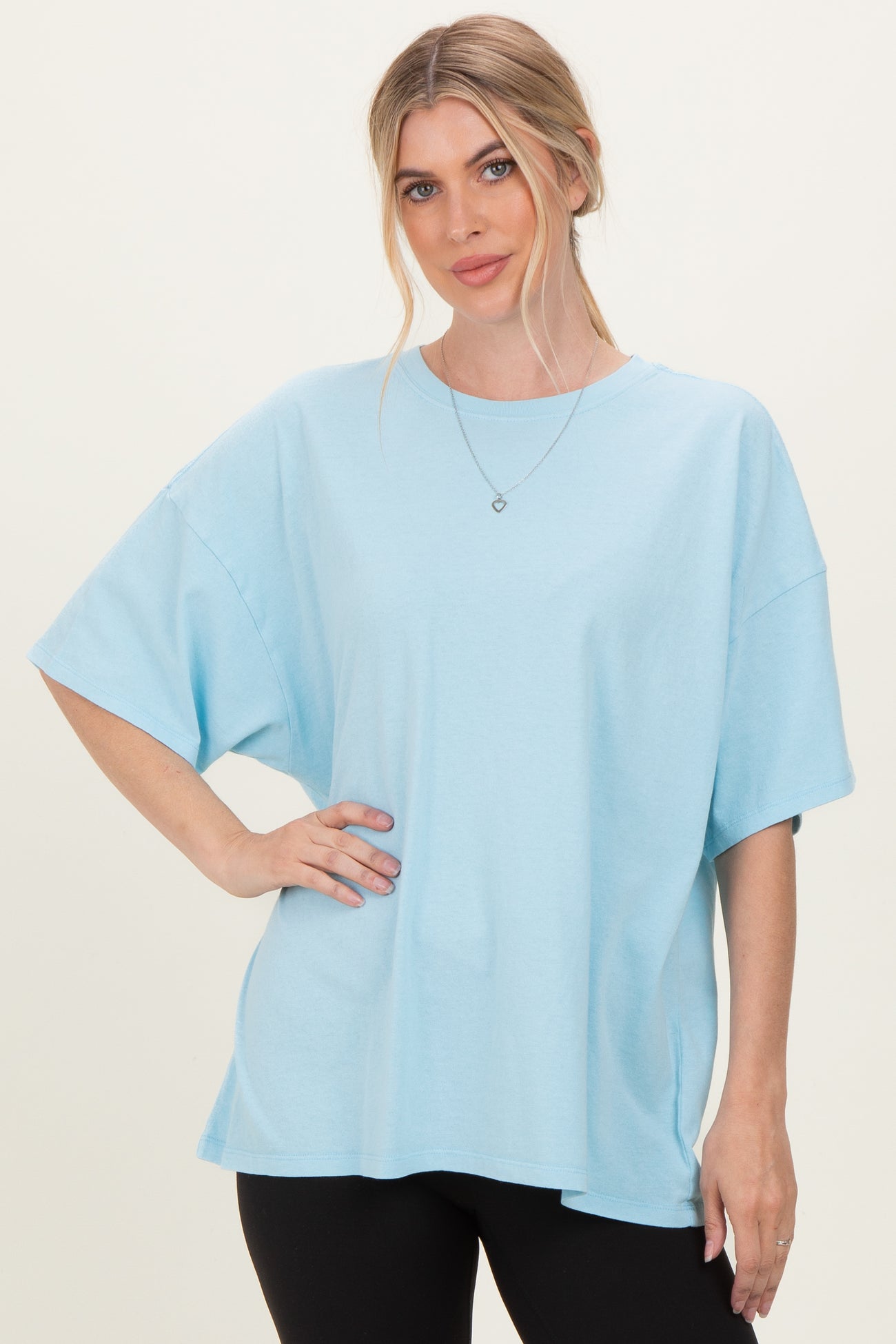 woman wearing a light blue oversized t-shirt with short sleeves and a relaxed fit