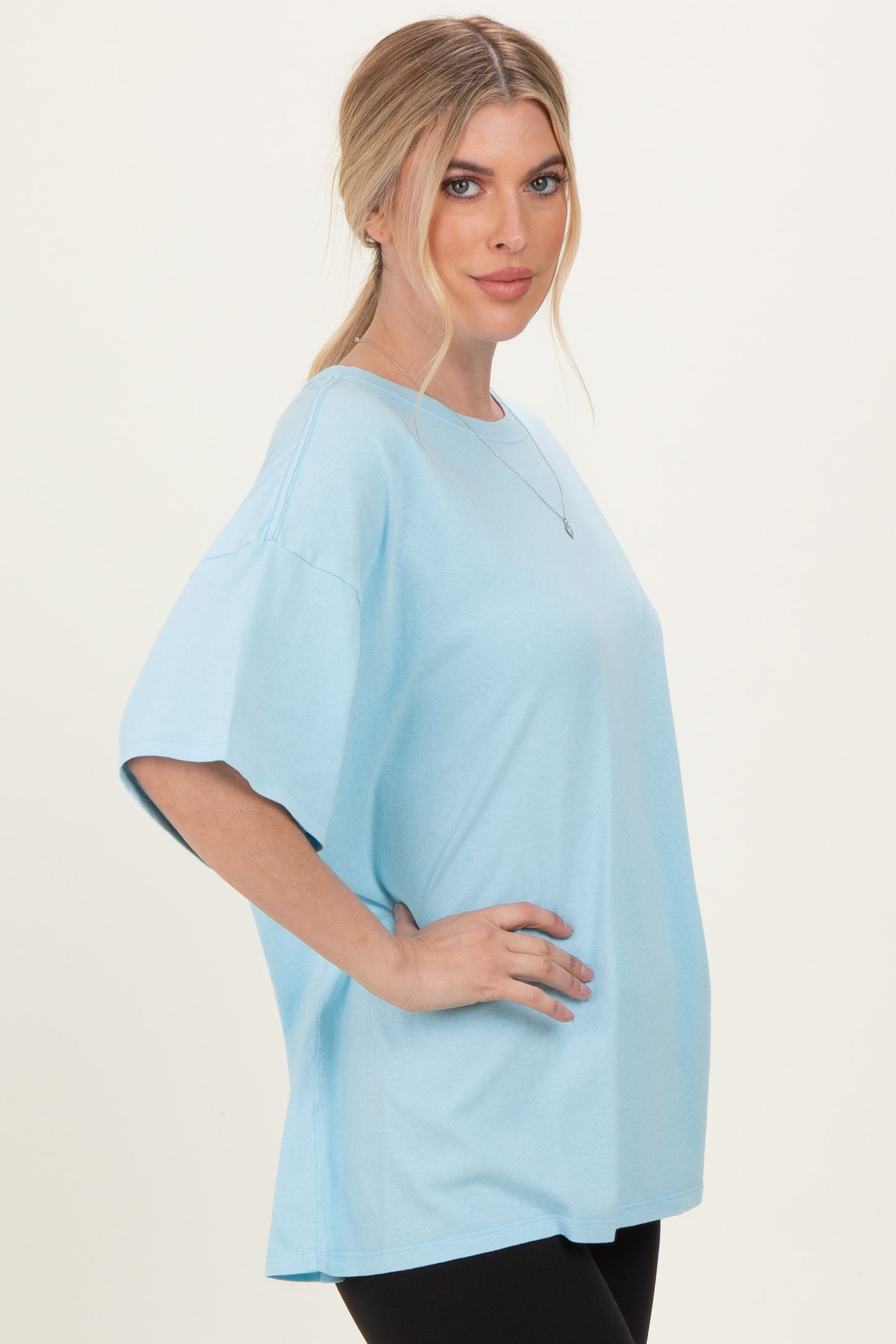 woman wearing a light blue oversized t-shirt with short sleeves and a relaxed fit
