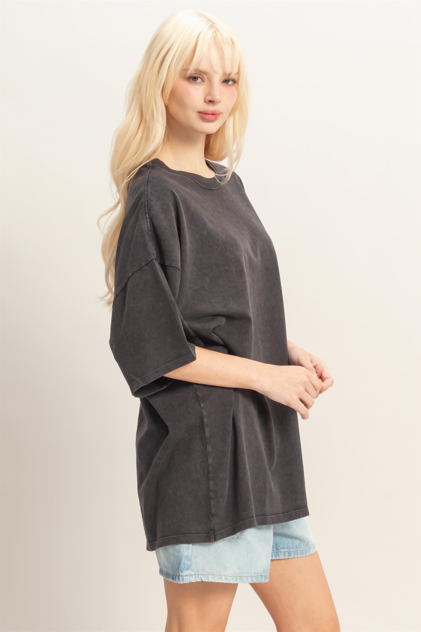 woman wearing an oversized black short sleeve t-shirt with a relaxed fit and light blue denim shorts
