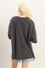 woman wearing a dark grey oversized t-shirt from the back, paired with denim shorts