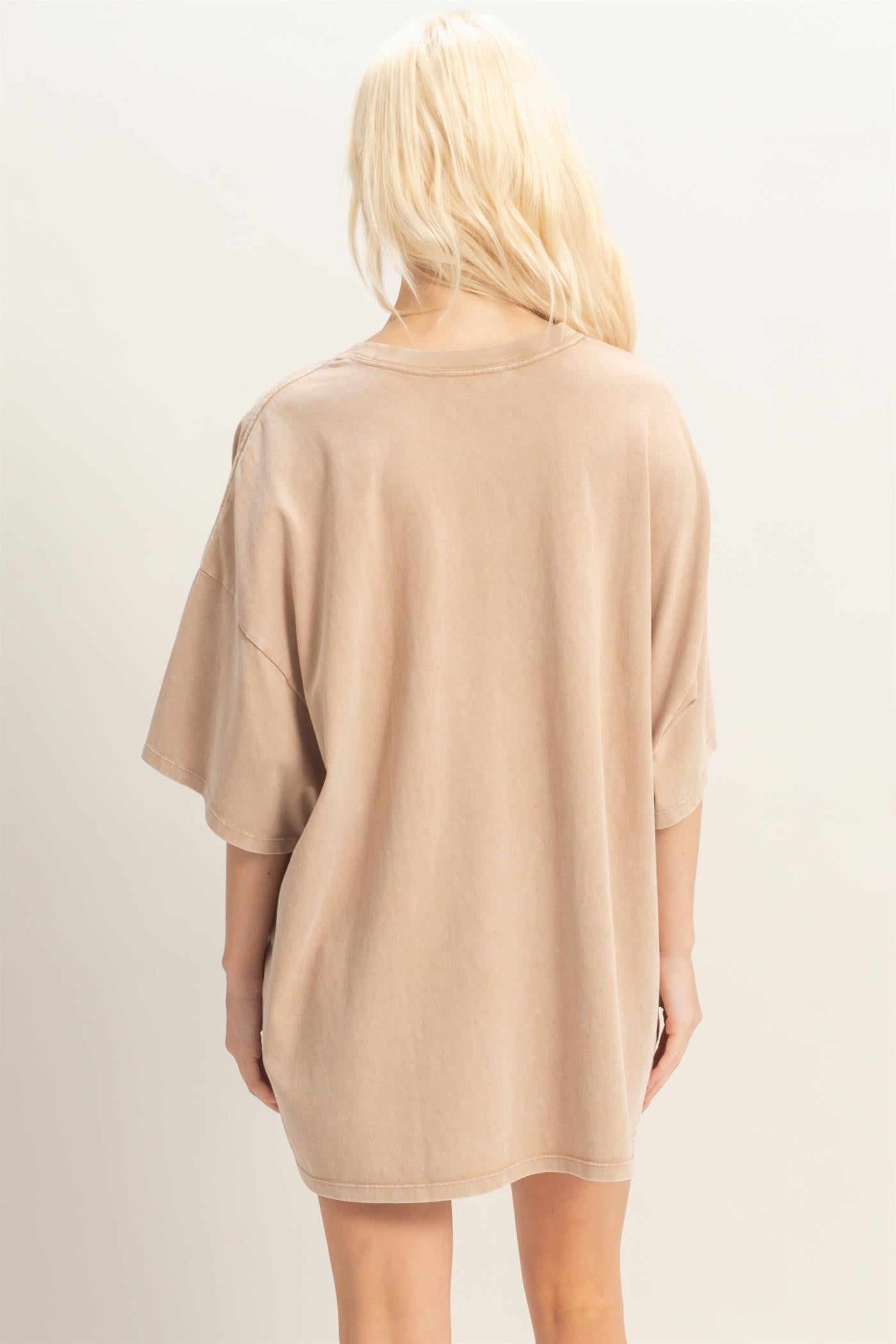 woman wearing a relaxed fit beige oversized t-shirt dress, view from the back