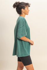 woman wearing a green oversized short sleeve top paired with black bike shorts