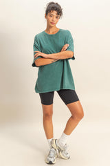 woman wearing a green oversized t-shirt with short sleeves and black bike shorts