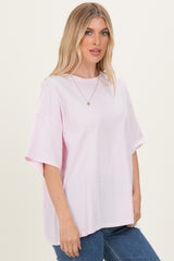 woman wearing a oversized light pink short sleeve t-shirt with a round neckline and relaxed fit