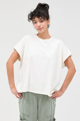 woman wearing a loose-fitting cream short sleeve t-shirt and light green cargo pants