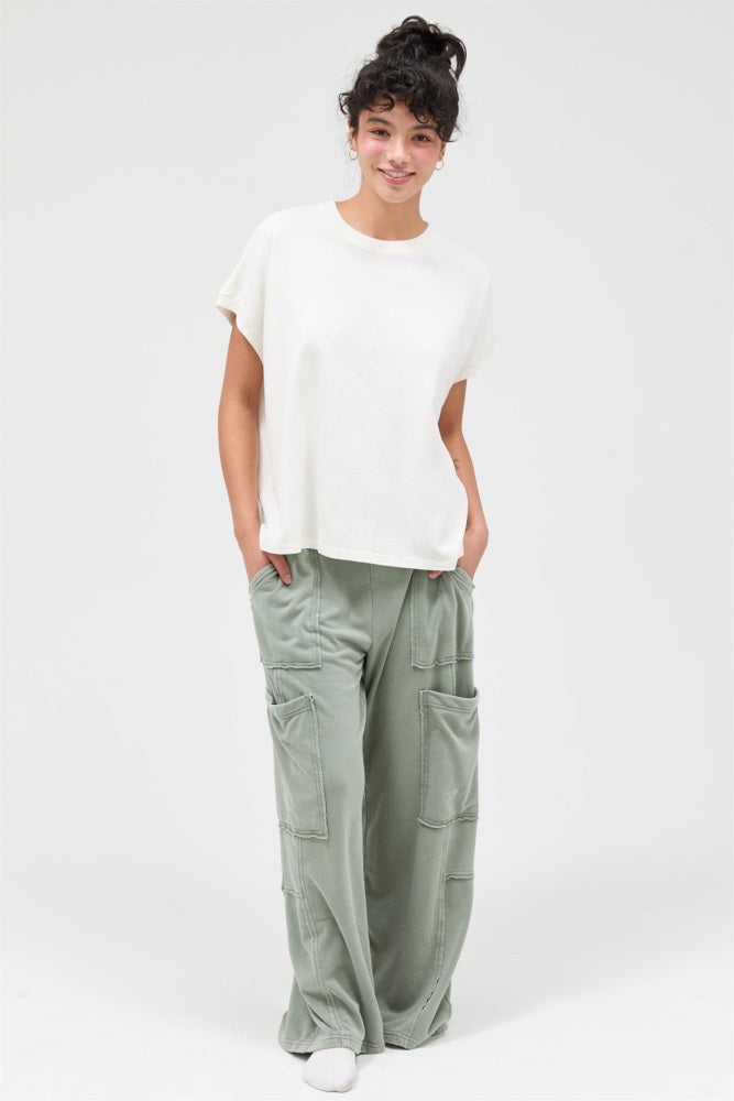 woman wearing a cream short sleeve top and olive green cargo pants with side pockets