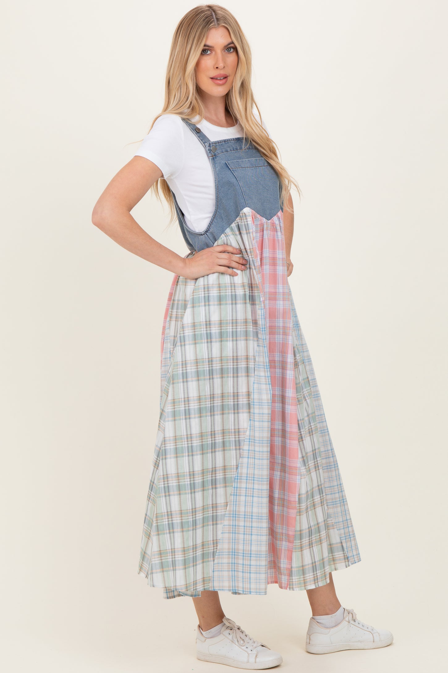 woman wearing a denim and plaid maxi dress with a white t-shirt underneath and white sneakers