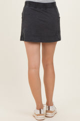woman wearing a dark gray maternity skort with pockets, viewed from the back