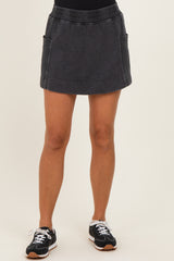 woman wearing a black denim mini skirt with side pockets and a stretchy waistband