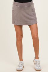 woman wearing a gray maternity mini skirt with pockets and an elastic waistband