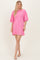 woman wearing a bright pink oversized t-shirt dress with short sleeves and a relaxed fit