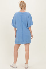 woman wearing a light blue oversized sweatshirt dress with short sleeves and a relaxed fit