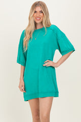 woman wearing a bright turquoise oversized t-shirt dress with short sleeves and a relaxed fit