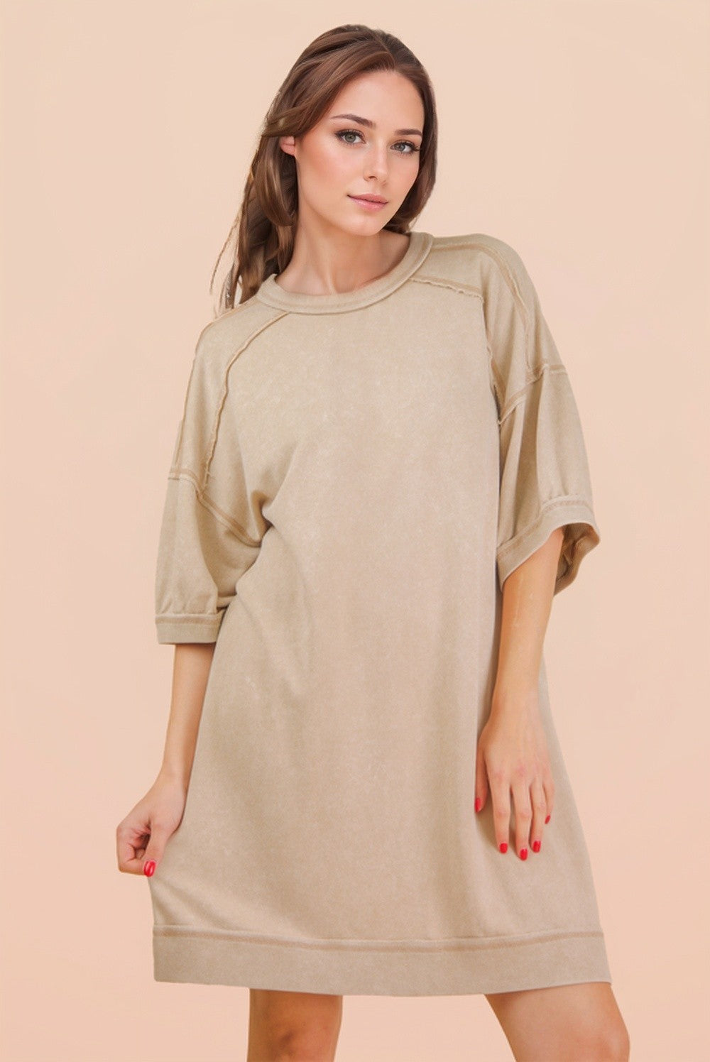 woman wearing a loose-fitting beige oversized t-shirt dress with short sleeves