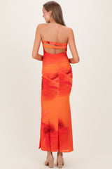 woman wearing a strapless orange maternity dress with floral print and ruching details, showing her back