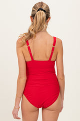woman wearing a red maternity swimsuit, showing the back view with adjustable straps