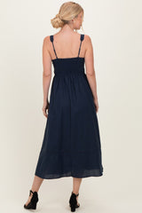 woman wearing a navy blue sleeveless maxi dress with a smocked back and tiered detailing