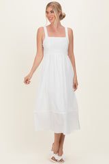 woman wearing a white sleeveless midi dress with a square neckline and tiered hem