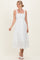 woman wearing a white sleeveless midi dress with a square neckline and tiered hem