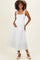 woman wearing a white maternity maxi dress with a square neckline and flowy skirt, holding her baby bump