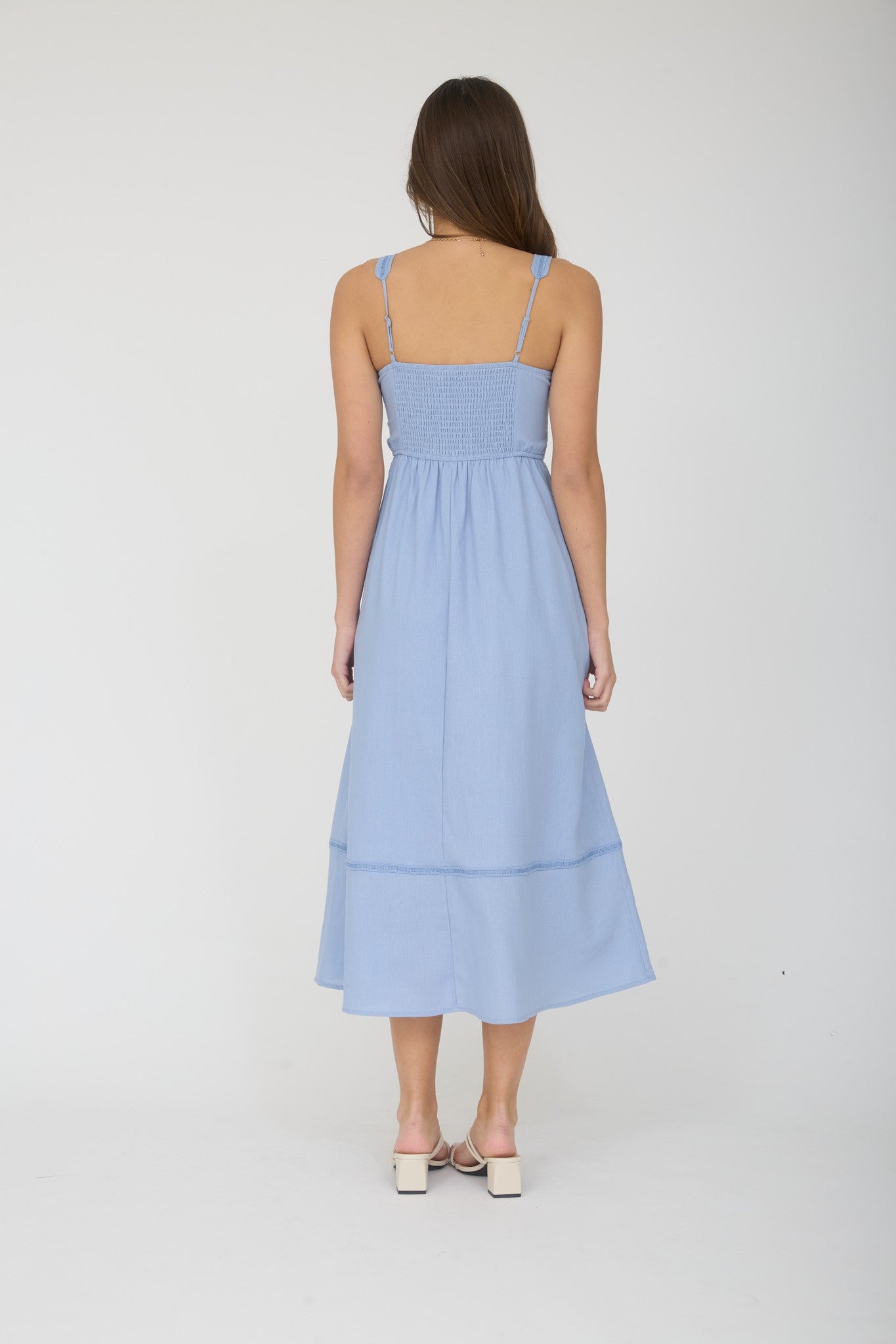 woman wearing a light blue smocked back maxi dress with spaghetti straps and tiered hem