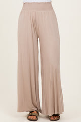 woman wearing beige wide-leg pants with a smocked waist and casual sandals
