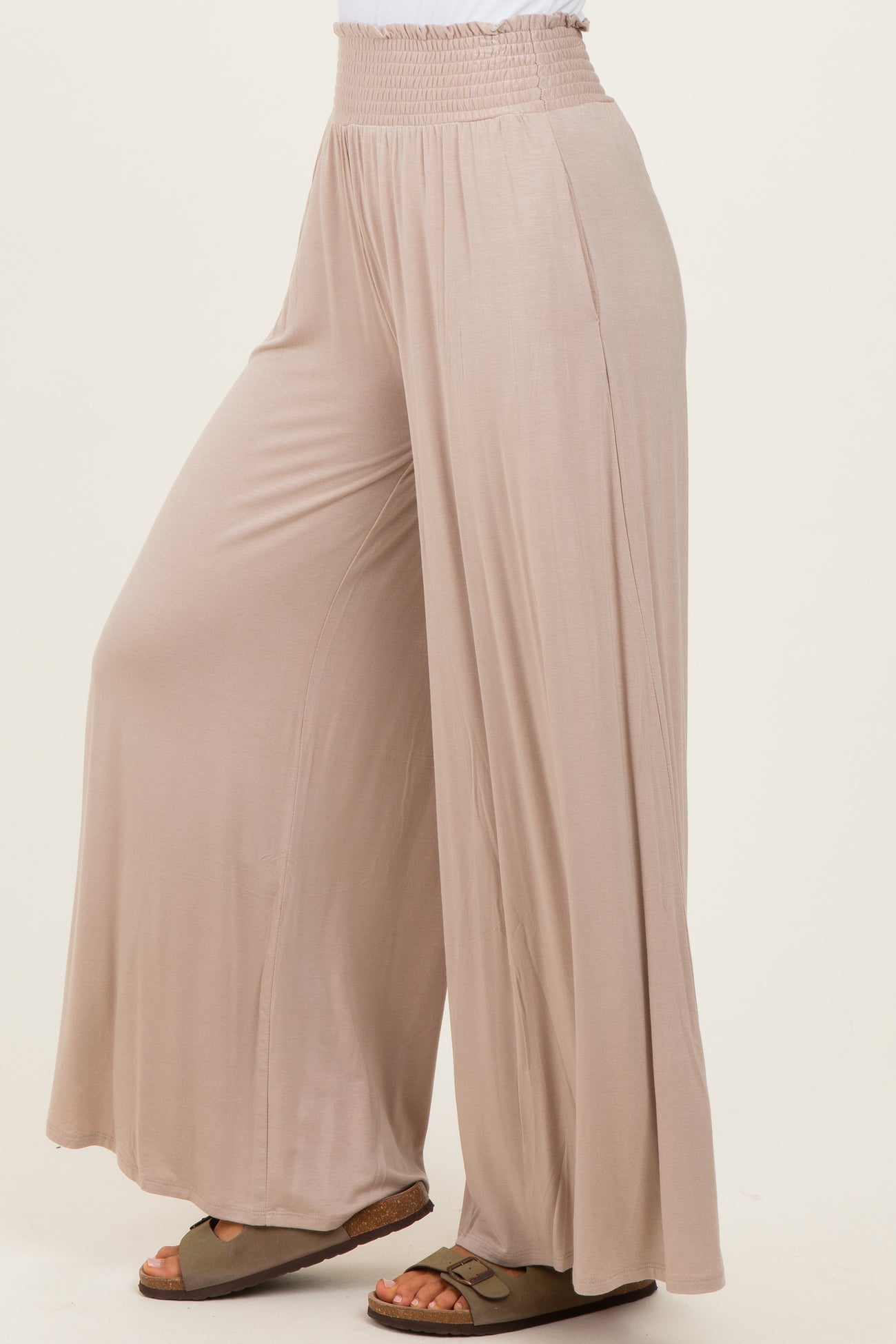 woman wearing light beige wide-leg pants with an elastic waistband and a relaxed fit