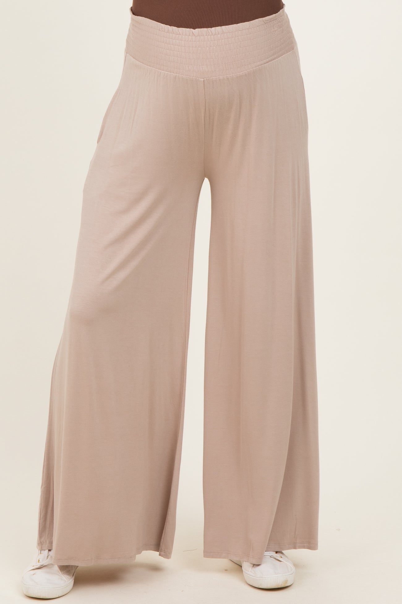 woman wearing light beige maternity wide leg pants with a relaxed fit and an elastic waistband