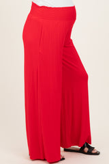 woman wearing a flowing red maternity maxi skirt with an elastic waistband and a visible baby bump