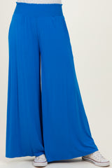 women wearing bright blue wide-leg pants with an elastic waistband and paired with white sneakers