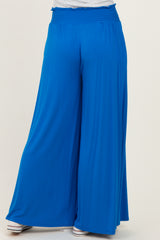 woman wearing a pair of bright blue wide-leg pants with a smocked waistband