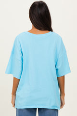 woman wearing a light blue oversized t-shirt viewed from the back, paired with blue jeans