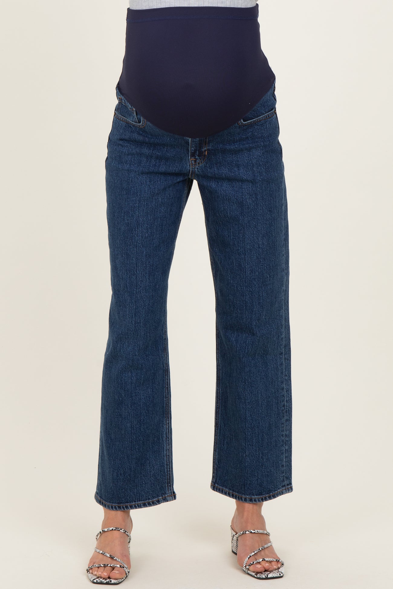 maternity wear dark blue straight leg jeans with a stretchy over-the-bump panel, model wearing high-heeled sandals