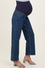 woman wearing a dark blue pair of maternity jeans with a soft belly panel, showcasing her baby bump