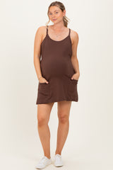 woman wearing a brown maternity dress with pockets and a baby bump visible