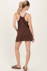woman wearing a brown sleeveless mini dress with a racerback style, showing a casual and relaxed fit