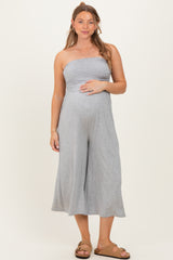 woman wearing a gray strapless jumpsuit, showing her baby bump with a relaxed fit and cropped wide legs