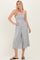 woman wearing a gray strapless jumpsuit with a fitted bodice and wide-leg pants