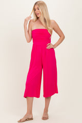woman wearing a bright pink strapless jumpsuit with wide leg culottes and a relaxed fit