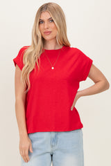 woman wearing a red short sleeve top with rolled sleeves and casual fit, paired with light blue jeans
