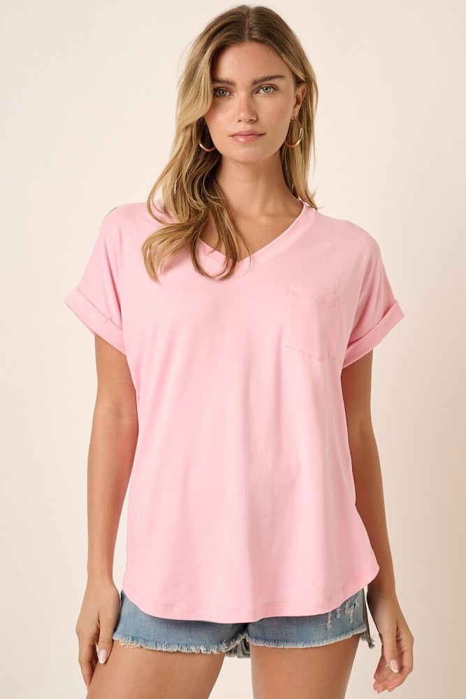 woman wearing a pink v-neck t-shirt with rolled sleeves and a pocket, styled with denim shorts