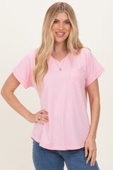 woman wearing a light pink short sleeve v-neck top with a front pocket and casual fit
