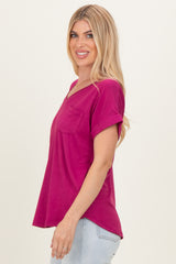 woman wearing a magenta short sleeve top with a pocket and rolled sleeves, smiling, styled with light jeans