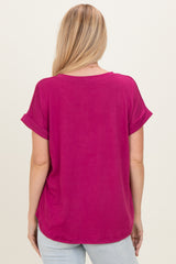 woman wearing a loose-fitting magenta top with rolled sleeves and a rounded hem, view from the back