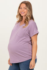 woman wearing a lavender maternity top with a v-neck and pocket, showcasing her baby bump