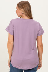 woman wearing a lilac maternity top with short rolled sleeves, showing a relaxed fit and longer back hem