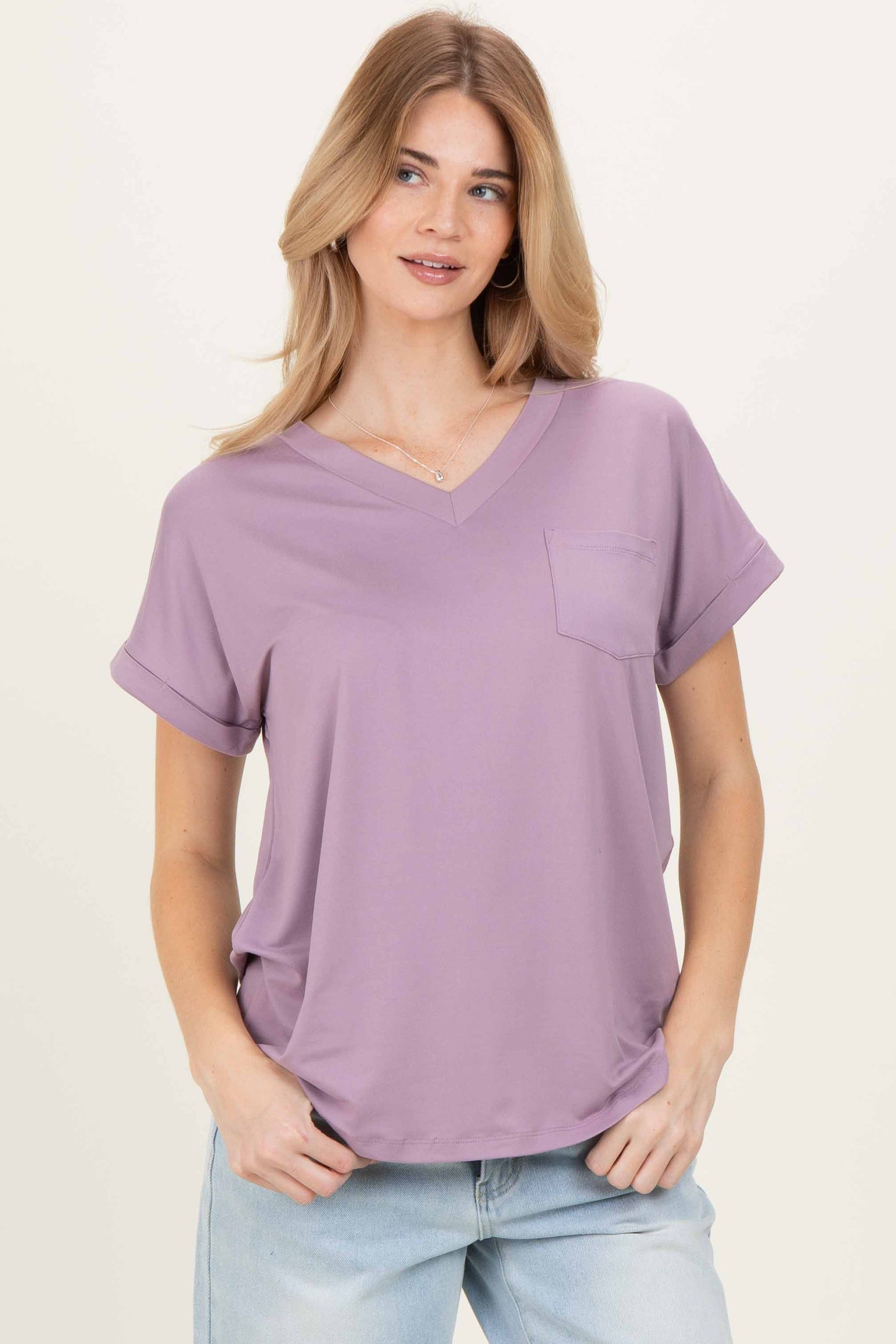 woman wearing a lavender v-neck short sleeve t-shirt with a chest pocket and rolled sleeves