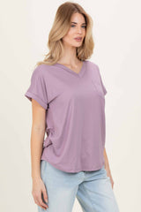 woman wearing a lavender v-neck loose-fit top with rolled sleeves and a front pocket